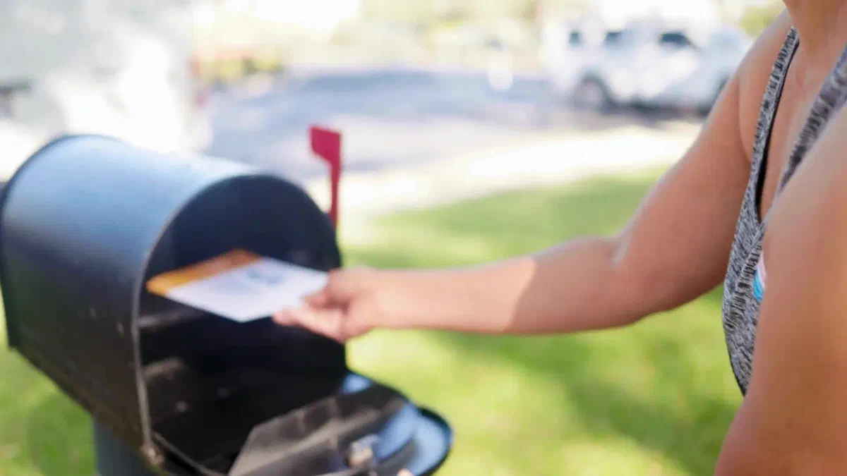 Mail being placed in a residential mailbox