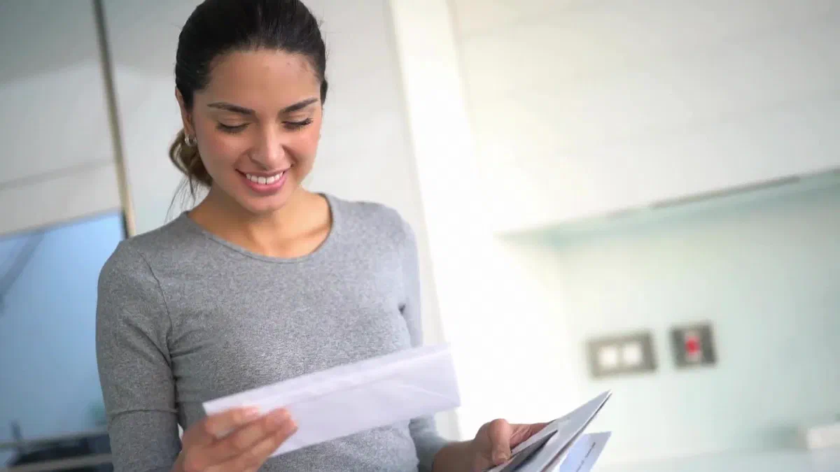 A woman reading mail that arrived at the right address